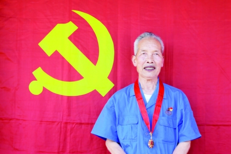 军工老战士薛仰珍与党旗合个影