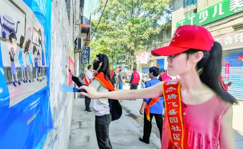 腾飞盛园社区在职党员清理巷道墙面