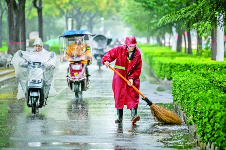 下雨，环卫工人也没有停下手中的扫把